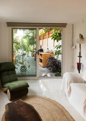 a bedroom with a sliding glass door to a patio at Private Cottage with bbq area 5 min walk to beach! in Dubai