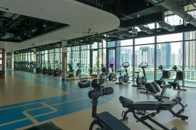 a gym with a lot of treadmills and exercise bikes at Spacious and Elegant 2BR Marina Gate 2 in Dubai