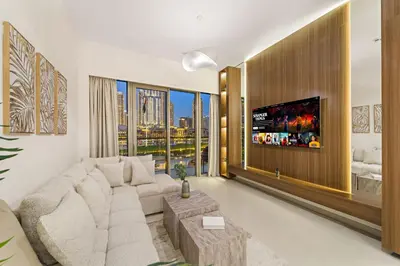 a living room with a couch and a tv at Panoramic 2BR with Pool & Burj View Next to Mall in Dubai