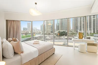 a bedroom with a large bed and large windows at Panoramic 2BR with Pool & Burj View Next to Mall in Dubai