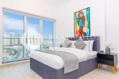 a bedroom with a bed and a large window at Bloomfields Stylish 1br Orchid Residence in Dubai