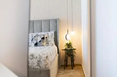 a bedroom with a bed with a gray headboard at 4BHK in Business Bay w Burj Khalifa View Noora 4304 in Dubai