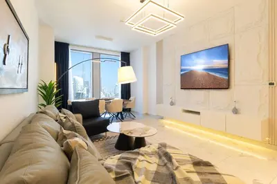 a living room with a couch and a tv at 4BHK in Business Bay w Burj Khalifa View Noora 4304 in Dubai