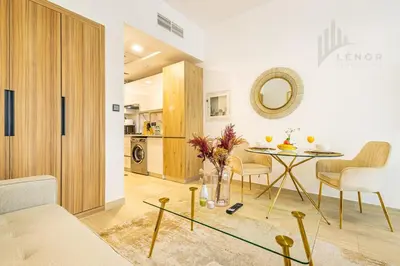 a living room with a table and a mirror at Chic Studio Living JVC in Dubai