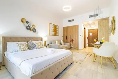 a bedroom with a large bed and a living room at Chic Studio Living JVC in Dubai