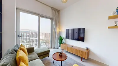 a living room with a couch and a tv at Cozy and Modern 1BR in Dubai Hills in Dubai