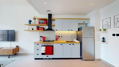 a kitchen with white cabinets and a stainless steel refrigerator at Cozy and Modern 1BR in Dubai Hills in Dubai