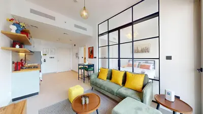 a living room with a green couch and yellow pillows at Cozy and Modern 1BR in Dubai Hills in Dubai