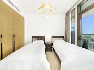 two beds in a room with a window at Palace residence creek harbour in Dubai