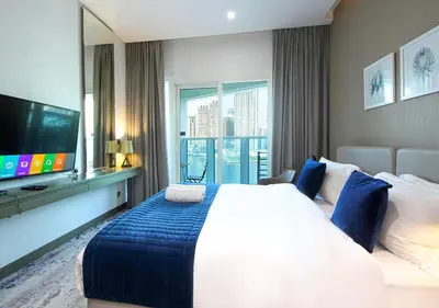 a bedroom with a large bed and a flat screen tv at Modern Canal View with Balcony Damac Prive Dubai in Dubai