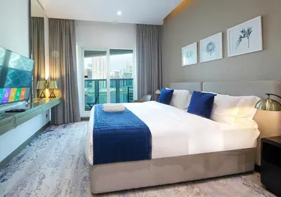 a bedroom with a large bed and a flat screen tv at Modern Canal View with Balcony Damac Prive Dubai in Dubai