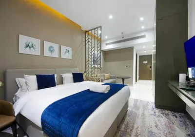 a bedroom with a large bed with a blue blanket at Modern Canal View with Balcony Damac Prive Dubai in Dubai