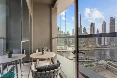 a balcony with two tables and a view of the city at Luxe 2 Bedroom with Burj Khalifa and Canal Views in Dubai