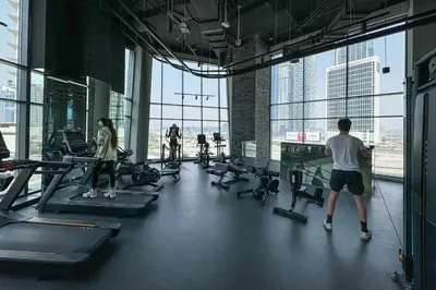 a group of people exercising on treadmills in a gym at Luxe 2 Bedroom with Burj Khalifa and Canal Views in Dubai