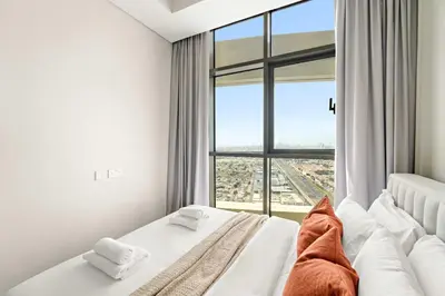 a bedroom with a bed with a large window at Silkhaus Spacious 2BR in Aykon City Near Safa Park in Dubai