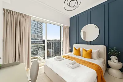 a bedroom with a bed and a large window at Silkhaus Homey 2BR at Mayfair Tower in Business Bay in Dubai