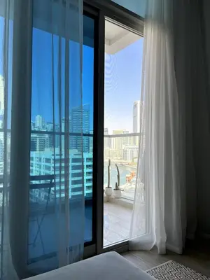 a bedroom with a large window with a view of the city at The Designers Apartment Dubai Marina in Dubai