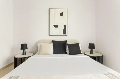 a bedroom with a large white bed with two lamps at VayK - Luxury 2BR with Jacuzzi in JVC in Dubai