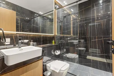 a bathroom with a sink and a toilet and a shower at VayK - Luxury 2BR with Jacuzzi in JVC in Dubai