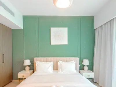 a bedroom with a bed with a green wall at Spectacular Burj Khalifa View, 2BR Luxury Apartment by SBH in Dubai