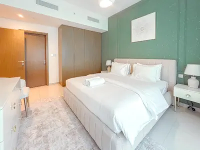 a bedroom with a large bed and a green wall at Spectacular Burj Khalifa View, 2BR Luxury Apartment by SBH in Dubai
