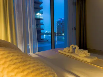 a bedroom with towels on a bed with a view at Luxury 1BR with Aquatic View, District One in Dubai