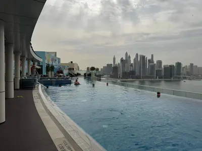 a swimming pool with a city in the background at Dubai Palm Jumeirah - Free Infiniti Pool and Private Beach in Dubai