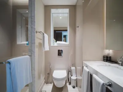 a bathroom with a toilet and a sink and a mirror at Address Dubai Mall Residences in Dubai
