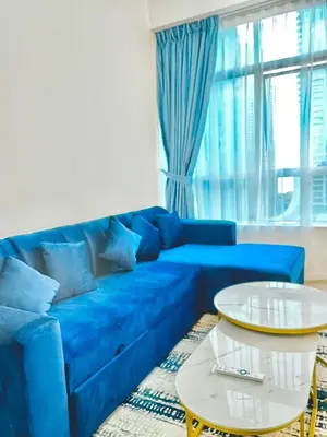a blue couch in a living room with a table at Stunning 2BR Marina View Apt Close to JBR in Dubai
