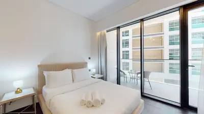 a bedroom with a bed with two white shoes on it at O Ten Al Jaddaf - Stylish Studio in Dubai
