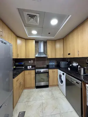 a kitchen with wooden cabinets and a washer and dryer at Click Stay - JLT - 2 Bedroom & Balcony Lakes View Entire Apartment -SS in Dubai