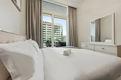 a bedroom with a white bed with a large window at Apartment in Downtown Dubai in Dubai