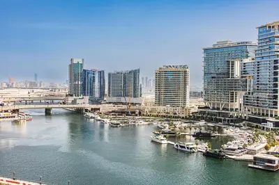 a river with boats in a city with tall buildings at Apartment in Downtown Dubai in Dubai