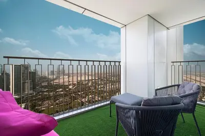 a balcony with two chairs and a view of a city at Luxury Stay Burj Views and Direct Dubai Mall Access in Dubai