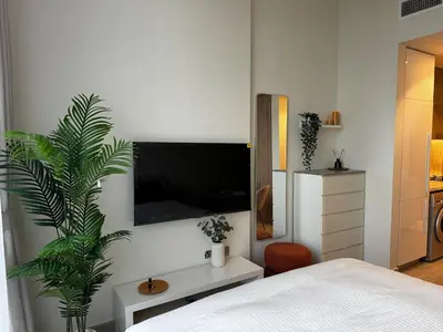 a bedroom with a bed and a tv on a wall at Sunlit serenity Studio Azizi Riviera in Dubai