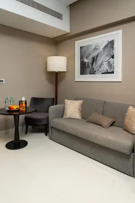 a living room with a couch and a table at Damac Maison Prive, Lake View - Free Parking in Dubai
