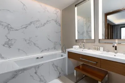 a bathroom with a tub and a sink and a mirror at Maison Privee - Exclusive Apt with Unmatched Burj Khalifa Views in Dubai