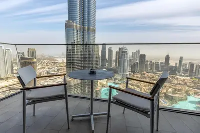 a table and chairs on a balcony with a view of the city at Maison Privee - Exclusive Apt with Unmatched Burj Khalifa Views in Dubai