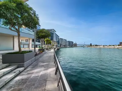a river in a city with buildings and trees at Brand new 1BD apartment in Canal Front Residence in Dubai