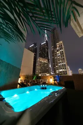 a swimming pool with a city skyline at night at 3BR Loft I Burj Khalifa & Mall in Dubai