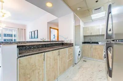 a large kitchen with a washer and dryer at Affordable Living 1BR, Steps from Retail Stores, Skycourts Tower D, Dubailand by Deluxe Holiday Homes in Dubai