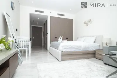 a bedroom with a bed and a living room at Mira Holiday Homes - Bright studio with Burj Khalifa view in Business Bay in Dubai