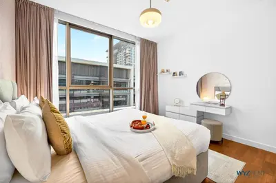 a bedroom with a bed with a large window at Lush 2BR & Maids City Walk with Burj Khalifa View in Dubai