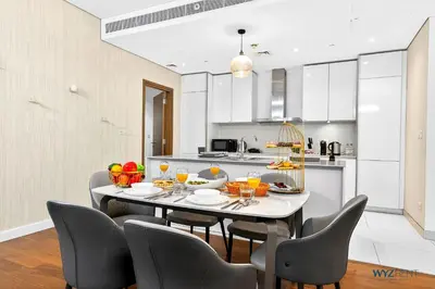 a dining room with a table and chairs in a kitchen at Lush 2BR & Maids City Walk with Burj Khalifa View in Dubai