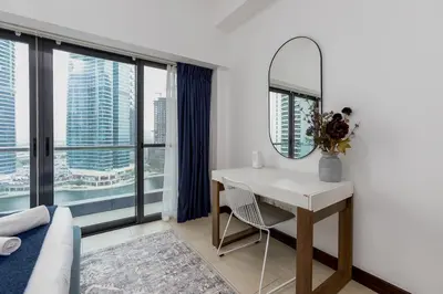 a room with a desk and a mirror and a bed at Full Lake View - 1BR Apartment in Goldcrest Views,Cluster V,JLT - Allsopp & Allsopp in Dubai