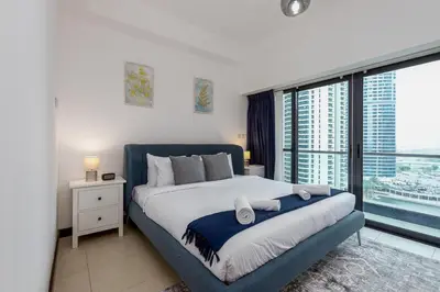 a bedroom with a large bed and a large window at Full Lake View - 1BR Apartment in Goldcrest Views,Cluster V,JLT - Allsopp & Allsopp in Dubai