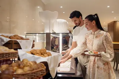 a man and a woman in a kitchen preparing food at Golden Sands Bur Dubai in Dubai