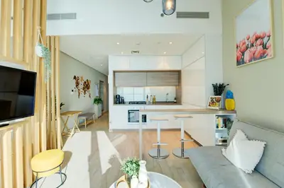 a living room with a couch and a kitchen at HiGuest - New! Stunning sea view studio, Balcony, Pool in Dubai