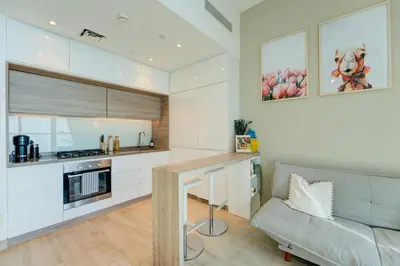 a living room with a couch and a kitchen at HiGuest - New! Stunning sea view studio, Balcony, Pool in Dubai