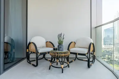 two chairs and a table in a room with a window at Luxury 3BR Apartment with Burj Khalifa Views in Dubai